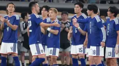青いユニホームを着た日本代表選手らが集まり声を掛け合っている