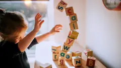 Criança brincando com blocos de letras