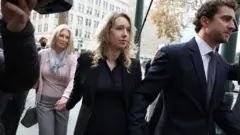 Holmes wen she  land for court on Friday