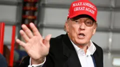 Trump com boné vermelho em que se lê o slogan 'Make America Great Again'