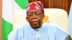 Aarẹ Bola Tinubu wọ agbada olomi aro pẹlu fila lori