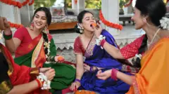 స్వీట్ తినిపించుకొంటున్న మహిళలు