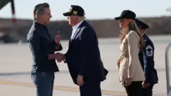 الرئيس الأمريكي دونالد ترامب يحيي حاكم كاليفورنيا جافين نيوسوم لدى وصوله في جولة بالمناطق المتضررة أو المدمرة بسبب حرائق الغابات في جنوب كاليفورنيا، في مطار لوس أنجلوس الدولي في لوس أنجلوس، كاليفورنيا، الولايات المتحدة.