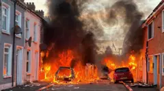 Автомобили, подожженные протестующими на Лендрик-стрит в Белфасте,