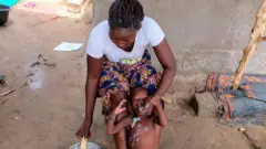 Aworan obinrin to n fipa rọ ọmọ lẹkọ mimu