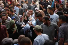 Grupo de palestinos em cortejo fúnebre no hospital Al-Shifa