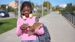 Foto of young girl wey dey type for her phone.