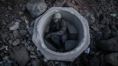 Van yakınlarındaki tren raylarının yanında bir lağım borusunun içine saklanan Afgan çocuk.