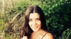 Нина Кутина улыбается на фоне зеленой растительности