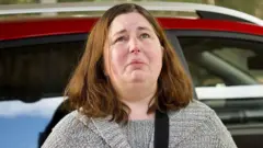 Эрин Паттерсон на фоне красной машины