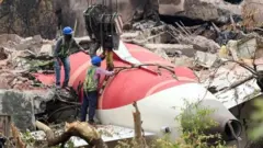 صورة تظهر عمالاً يرفعون حطام طائرة