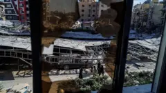 يمرّ الناس بجوار الأنقاض في موقع غارة إسرائيلية أعقبت اتفاقاً بين الولايات المتحدة وإيران في صور، جنوب لبنان، 16 يونيو/حزيران 2026.