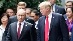 O presidente dos EUA, Donald Trump, e o presidente da Rússia, Vladimir Putin, conversam durante a sessão de fotos na Cúpula da APEC em Danang, Vietnã, 11 de novembro de 2017