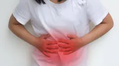 Criança com as mãos em cima da barriga