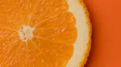 Laranja cortada sobre fundo laranja