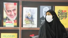 زینب سلیمانی در کنار کتاب‌هایی درباره پدرش