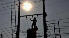 वीज खांबावर चढून काम करणारे कर्मचारी