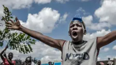A Kenyan gestures as he protests about the police beating someone during curfew - May 2020