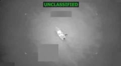 Sureveillance image of boat on water - it says declassified above it in green capped latters