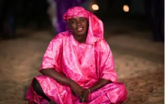 Wata mata a zaune ta yi kwalliya