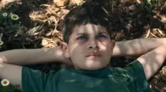 El protagonista de la película "El mar" está tumbado con los brazos y las manos colocados detrás de la cabeza en un fotograma del filme