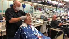 Un barbero atiende a su cliente en Atlanta.