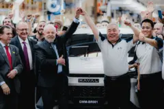 Do lado esquerdo da foto estão o presidente Luiz Inácio Lula da Silva; o vice-presidente e ministro do Desenvolvimento, Indústria, Comércio e Serviços, Geraldo Alckmin; e o ministro do Trabalho e Emprego, Luiz Marinho. Lula segura a mão erguida de Mu Feng, CEO da GWM global, que está ao lado de Parker Shi, presidente da GWM International, ambos do lado direito da foto. Ao fundo se vê um automóvel branco, que é o primeiro veículo produzido pela GWM na nova fábrica