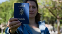 Kateryna Golizdra giơ hộ chiếu Ukraine của mình cạnh nhà riêng ở thành phố Margate, bang Florida vào hôm 17/11/2025