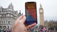 Aparelho celular com alerta e Big Ben ao fundo