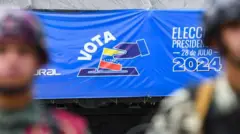 Militares delante de un cartel electoral promoviendo el voto en Venezuela. 