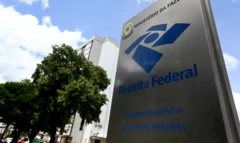 Totem com logotipo da Receita Federal ao lado de uma árvore