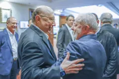 Meirelles e Lula se cumprimentam de forma calorosa