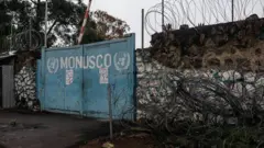 Muro com arame farpado na entrada na Missão de Estabilização da Organização das Nações Unidas
