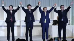 Mr Suga celebrates after being elected as head of the LDP