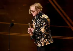 Amy Madigan carregando a estatueta