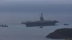 O maior porta-aviões do mundo, o USS Gerald R. Ford, com aviões de combate no convés, fotografado perto de uma ilha caribenha