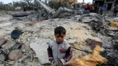 গাজা উপত্যকার খান ইউনিসে একটি বাড়িতে ইসরায়েলি হামলার স্থানে এক শিশু