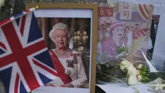 香港英國領事館外民眾擺放英女王伊麗莎白二世遺像與紀念她1975年訪問香港的繪畫（10/9/2022）