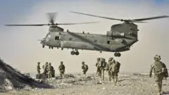 British soldiers approach a Chinook helicopter in the Nahr-e Saraj district, Helmand Province, Afghanistan