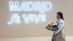 Garçonete leva bandeja com bebidas