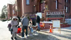 Una iglesia local ofrece café caliente y calentadores de manos cerca de un monumento improvisado en memoria de Alex Pretti en el sur de Mineápolis, Minesota.