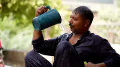 더위를 식히기 위해 몸에 물을 끼얹고 있는 파키스탄 남성