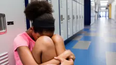 Girl wey dey hide her head for her legs or wetin look like school hall