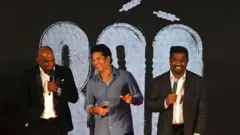 Former cricket player Sachin Tendulkar (C) of India speaks as Muttiah Muralitharan (R) and Sanath Jayasuriya of Sri Lanka watch during the trailer launch ceremony of '800', the biopic of Muralitharan, in Mumbai on September 5, 2023