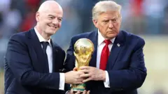 الرئيس الأمريكي دونالد ترامب (يمين) يمسك كأس العالم مع رئيس الفيفا جياني إنفانتينو