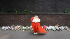 امرأة تضع الزهور بالقرب من مكان الحادث في كرويدون، جنوب لندن