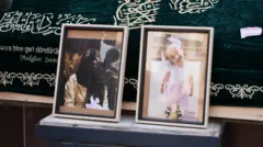 Bir tabutun önünde, İstanbul'da Zeytinburnu sahilinde ölü bulunan Fatmanur Çelik ve kızının yan yana fotoğraflarının yer alıyor. 