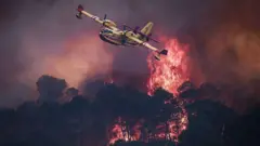 Una aeronave sobrevuela un incendio forestal en España.