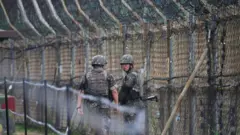 South Korean soldiers patrol along a fence in the Demilitarized zone