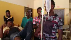 An injured man is seen on a drip in a medical centre